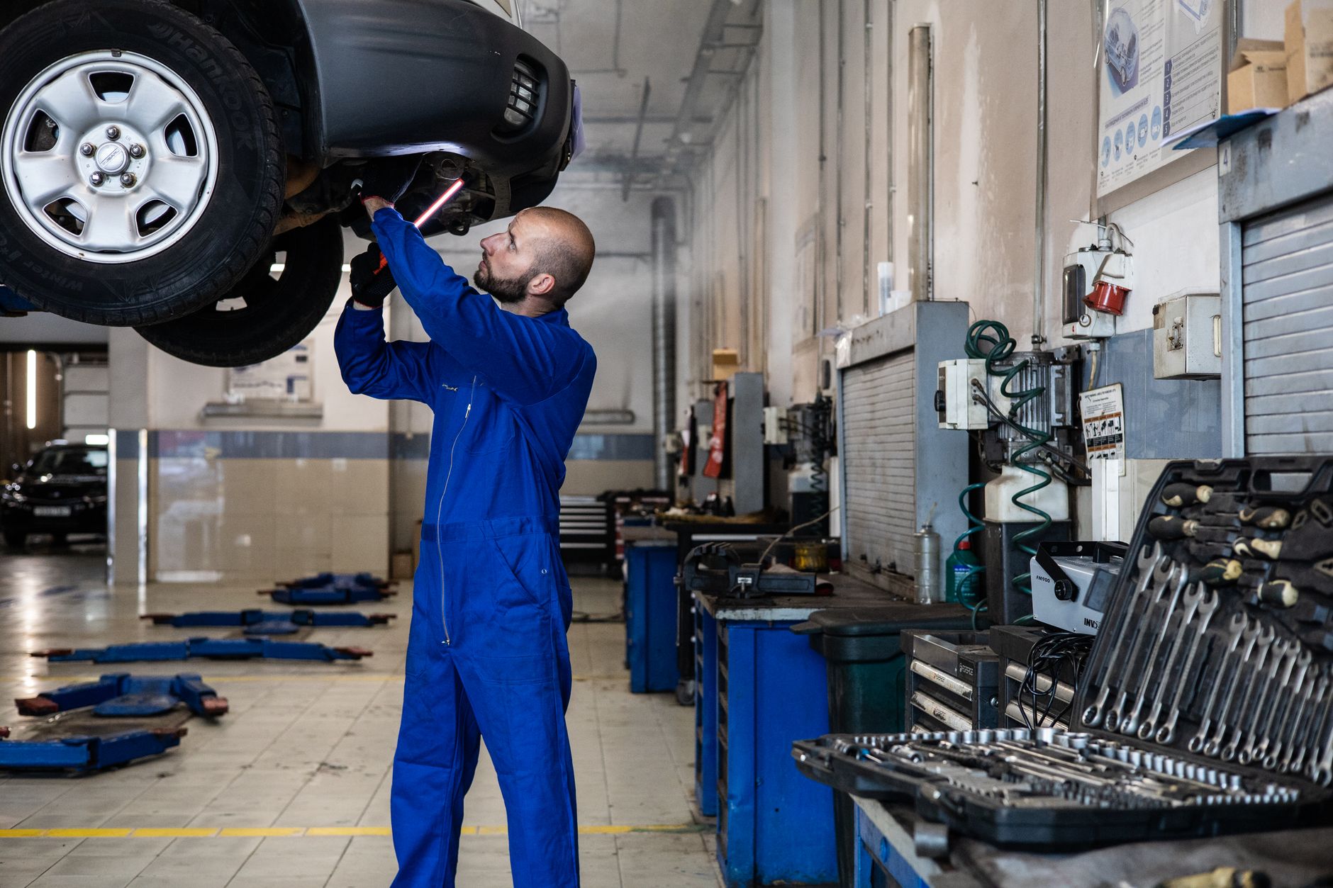Mechaniker prüft Auto auf Hebebühne
